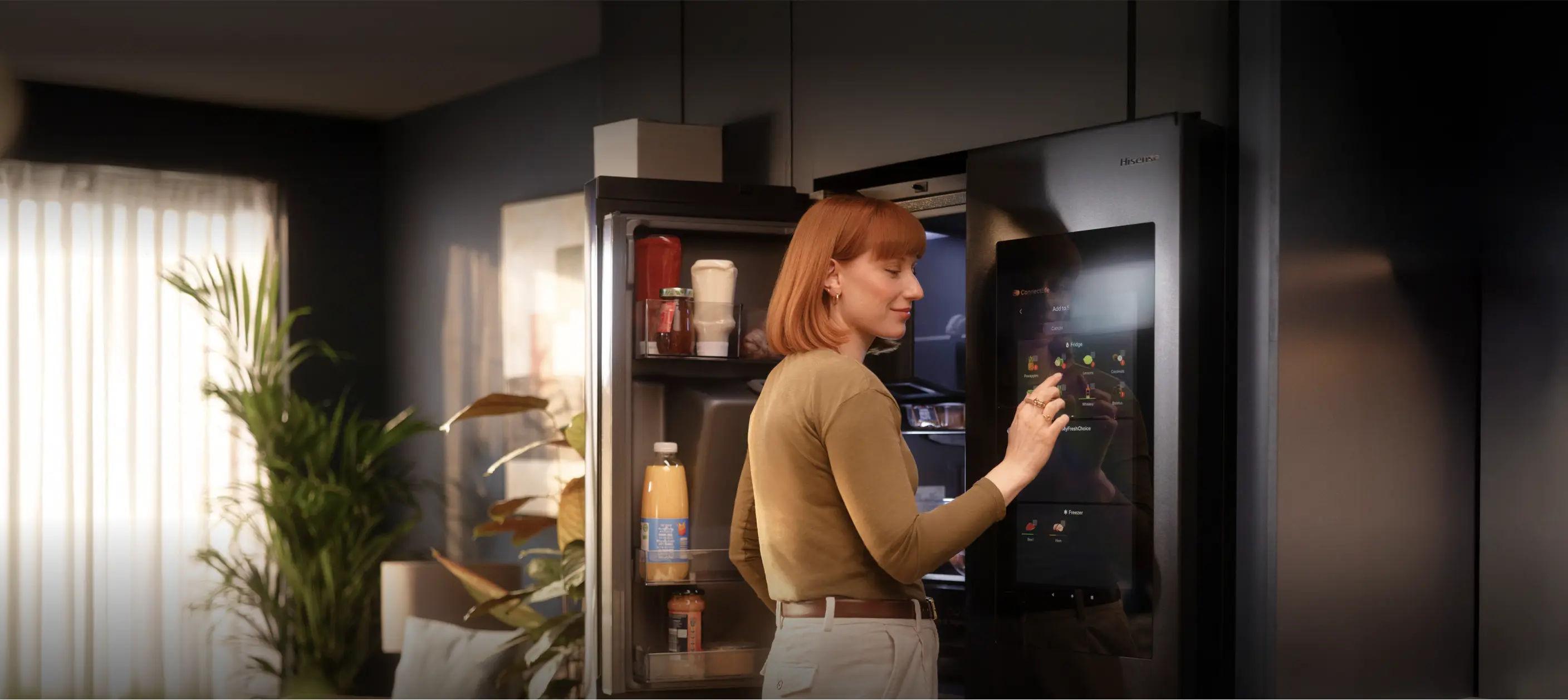 Lady stood at open Hisense fridge interacting with touchscreen Lady stood at open Hisense fridge interacting with touchscreen